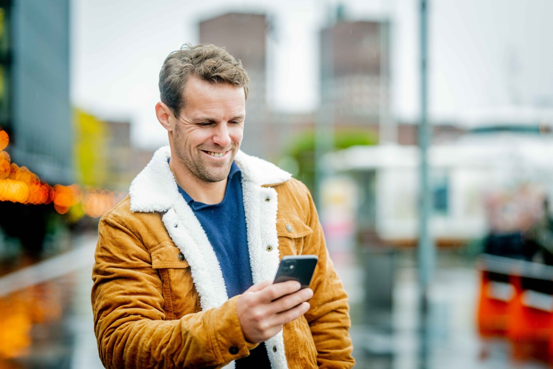 Mann som leser på mobilen - høst